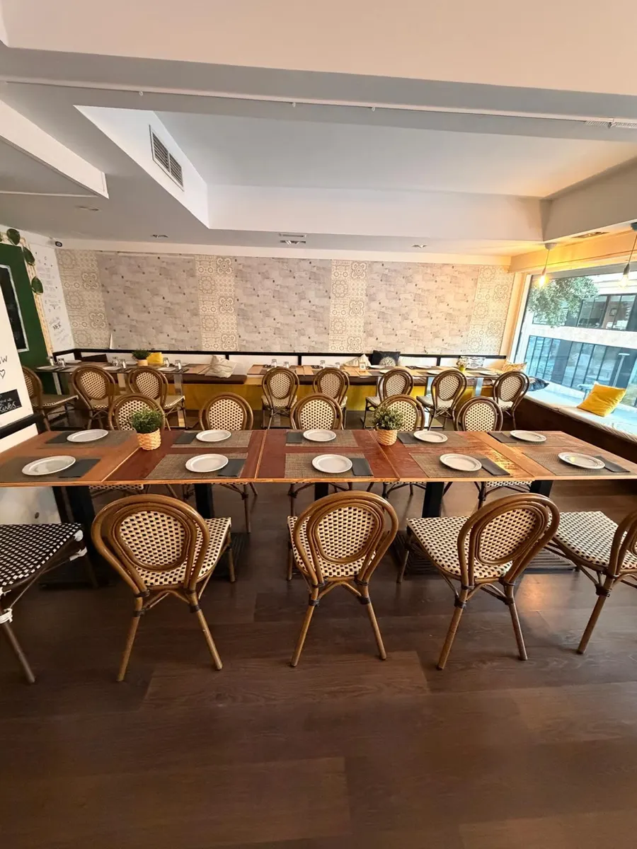 Salón superior con una mesa larga preparada para un grupo, vista desde arriba